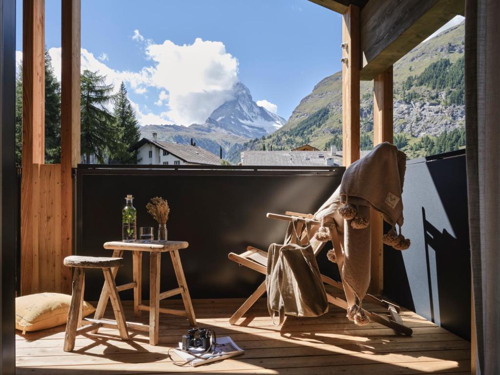 uma varanda com uma mesa e vista para uma montanha em Nomad by CERVO Mountain Resort em Zermatt