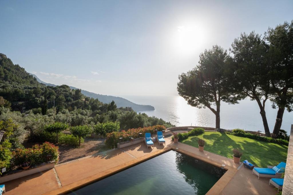 - une piscine avec des chaises et une vue sur l'eau dans l'établissement Villa Rafam - Deia, à Deià