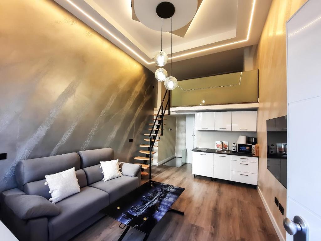 ein Wohnzimmer mit einem Sofa und einer Treppe in der Unterkunft Tofi 2 in Madrid