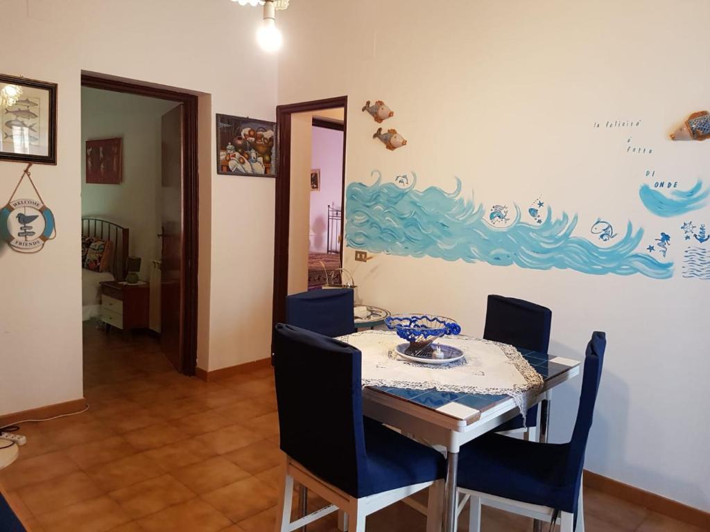 a dining room with a table and blue chairs at Da mare e d'amore in Spadafora