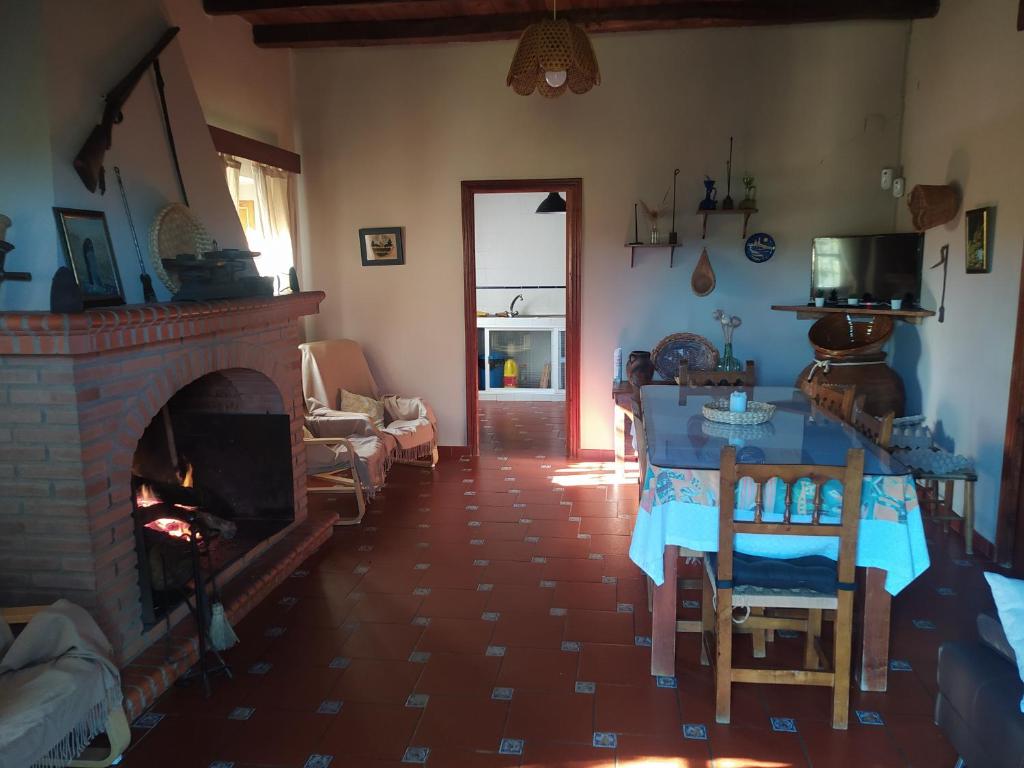 sala de estar con chimenea, mesa y sillas en Finca El Palomar, en Fuenteheridos