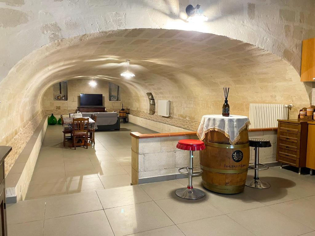 Habitación con un arco con barril y mesas en La perla di tufo, en Matera