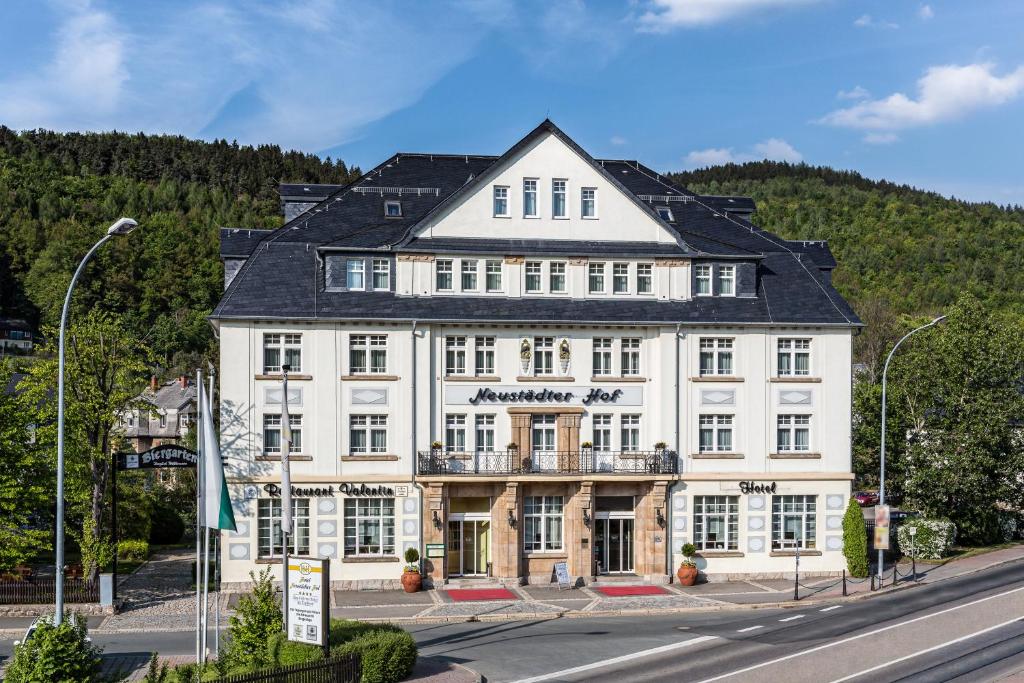 un grand bâtiment blanc sur le côté d'une rue dans l'établissement Hotel Neustädter Hof, à Schwarzenberg