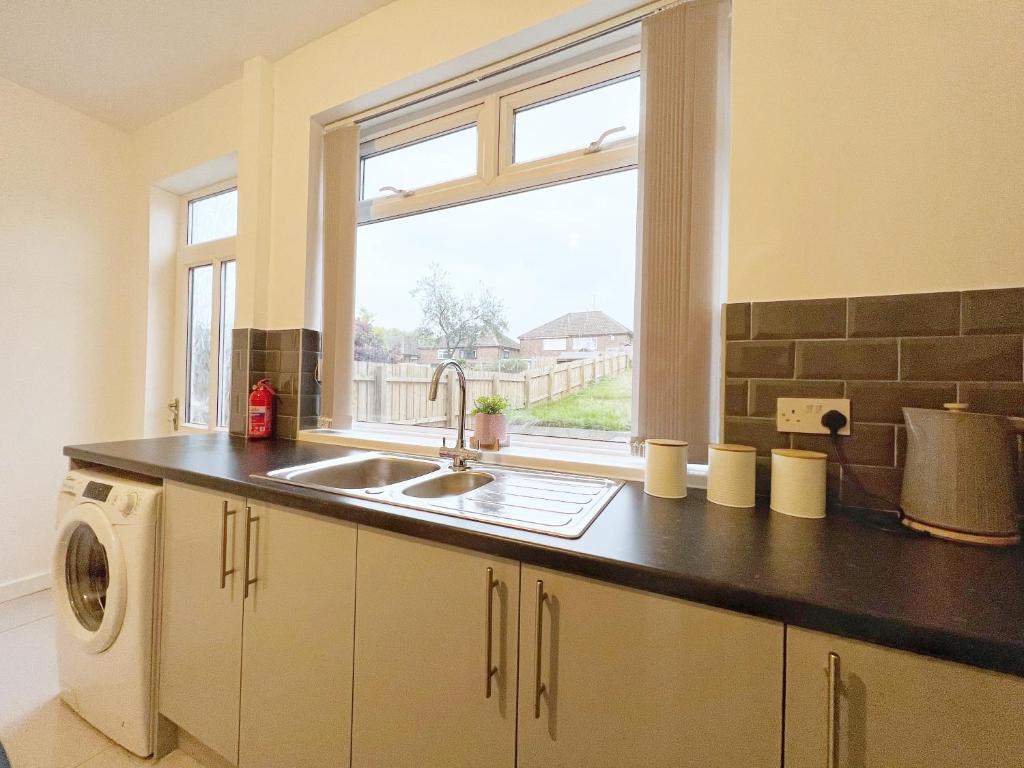 a kitchen with a sink and a window at Cheerful 3 bedroom home with Netflix and Wi-Fi in Middleton