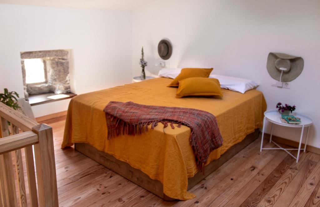 1 dormitorio con 1 cama grande con manta amarilla en CASA PARAFITA en Rosal