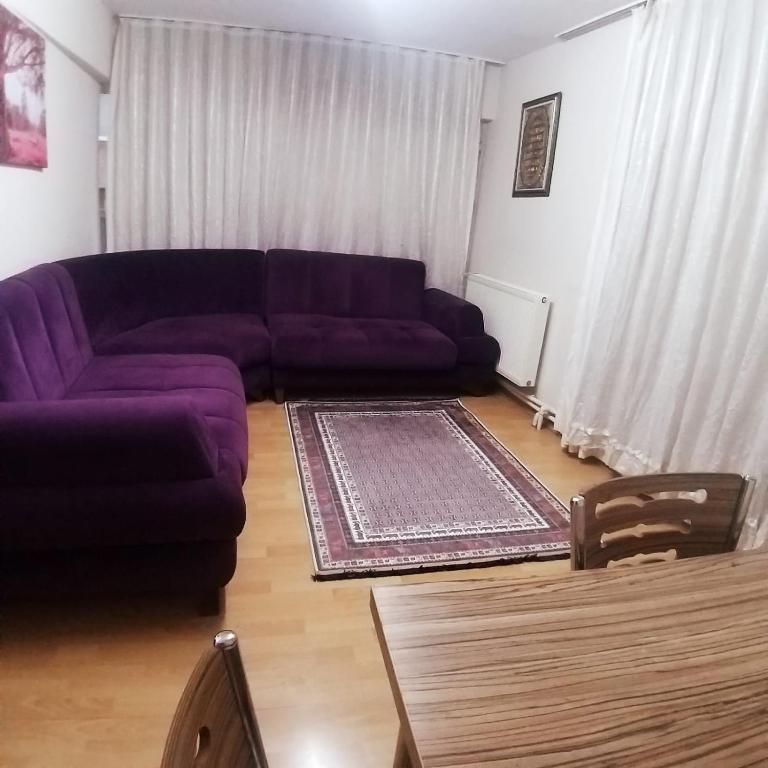 a living room with a purple couch and a table at home lovely in Bursa