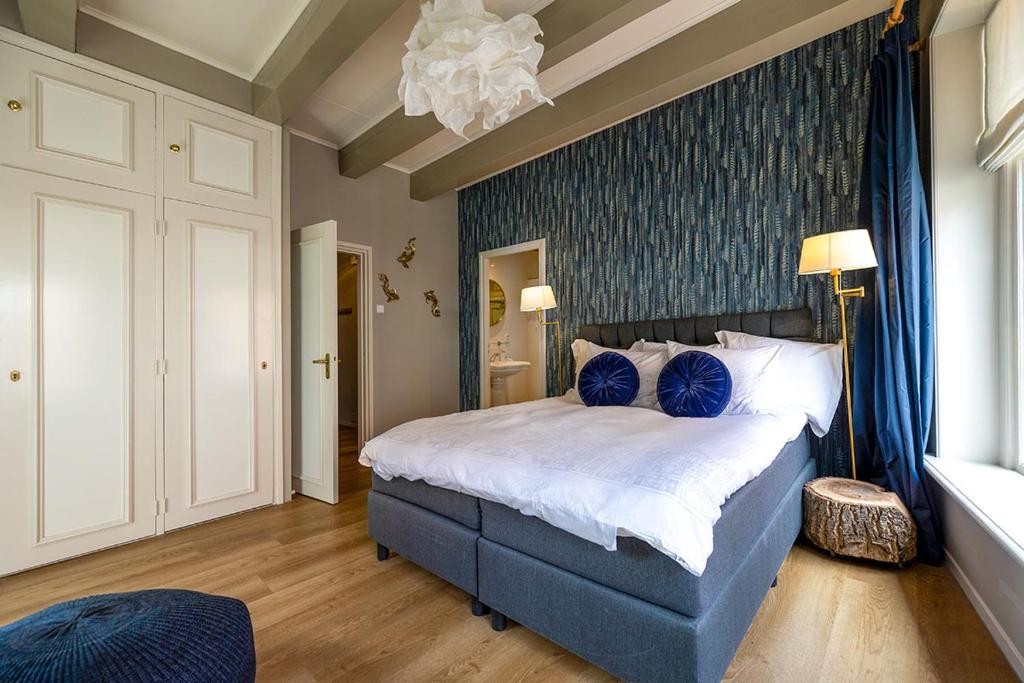 een slaapkamer met een groot bed met blauwe kussens bij Royal City Suite Monsieur Philippe in Leeuwarden