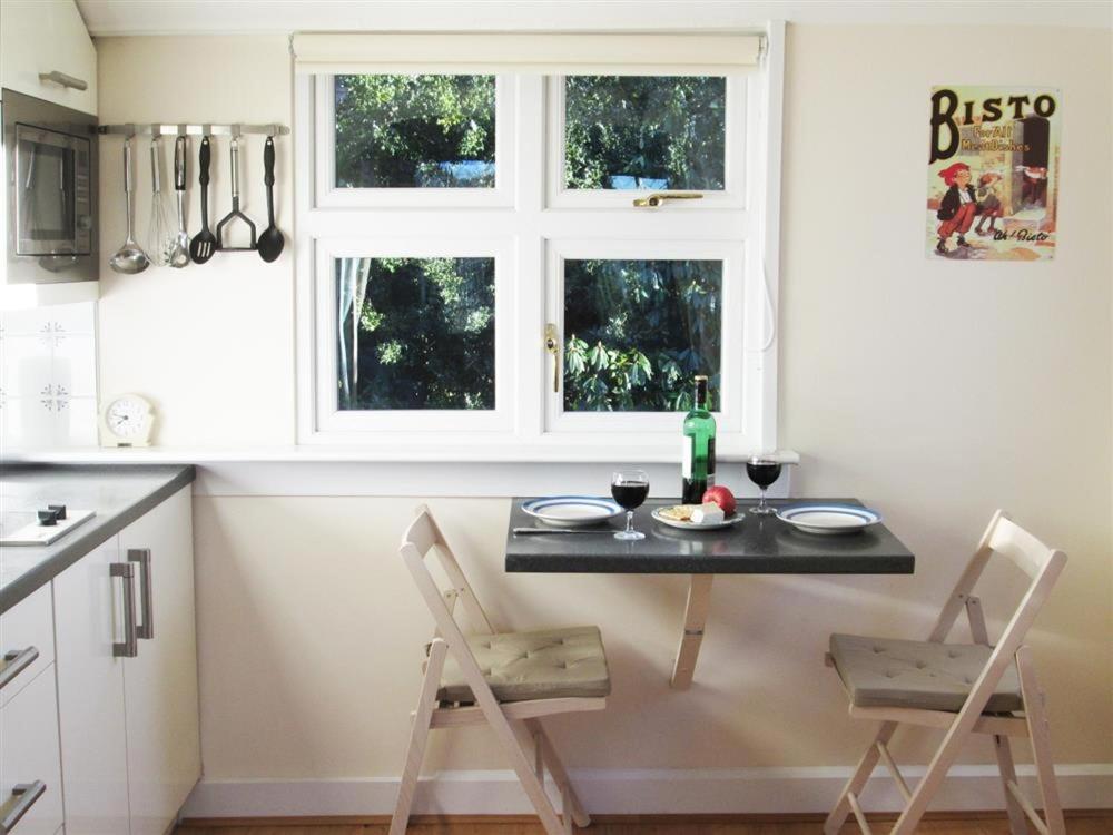 uma cozinha com mesa e cadeiras e uma janela em Shieling Beag em Banchory