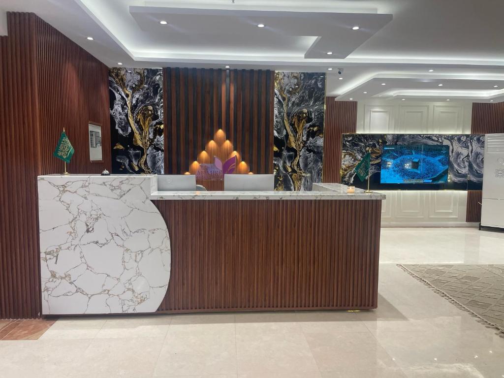 a hotel lobby with a reception counter with a display of fruit at Admire Apart' Hotel - Jeddah in Jeddah