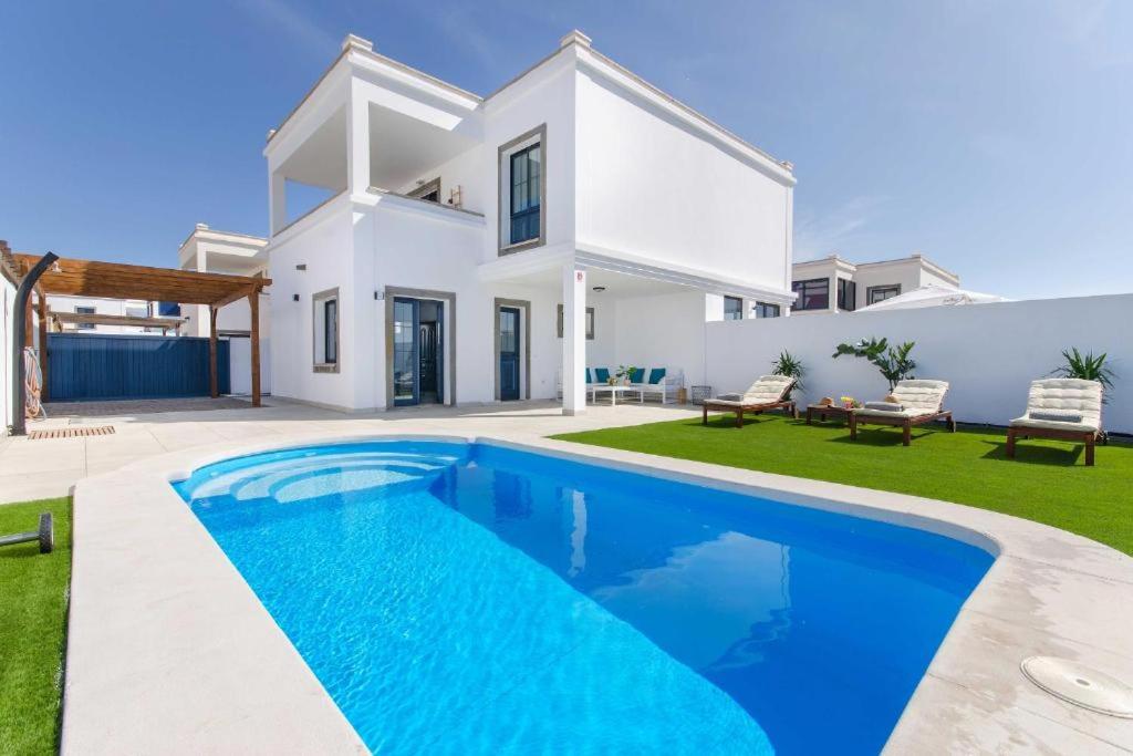 a villa with a swimming pool in front of a house at Casa Princesa Gara in Yaiza