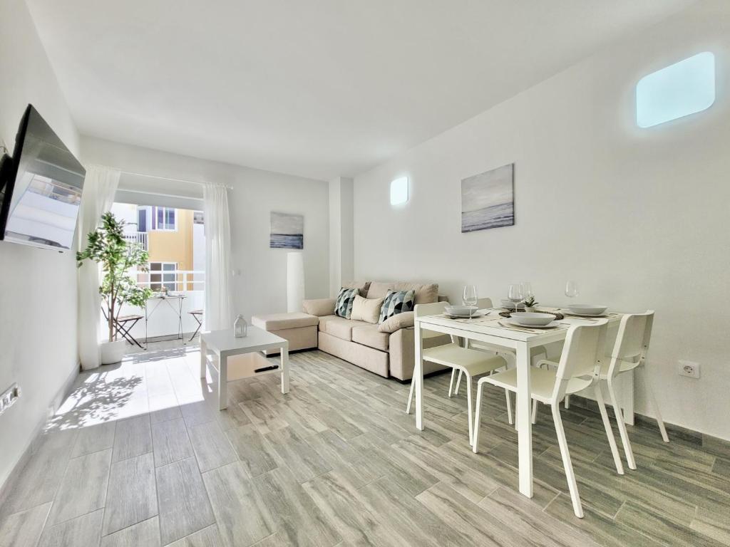 Biały salon ze stołem i kanapą w obiekcie La Hoya 29 Apartments w Puerto de la Cruz
