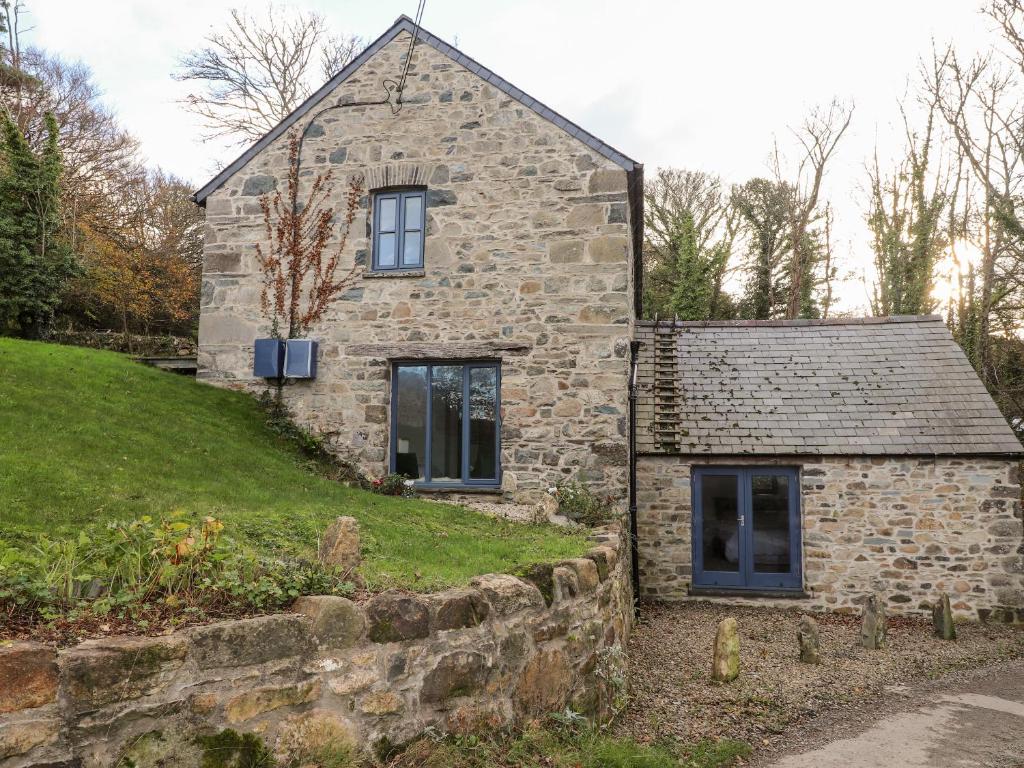 an old stone house on the side of a hill at Castle Mill in Newport Pembrokeshire