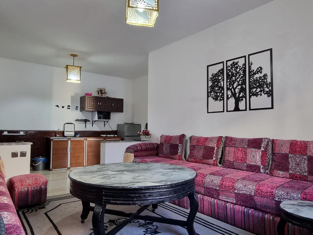 uma sala de estar com um sofá rosa e uma mesa em Spacious 2 BR near mausolée med V, 1min walk tram. em Rabat