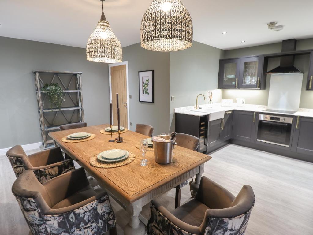 a kitchen and dining room with a wooden table and chairs at Magnolia in Hull