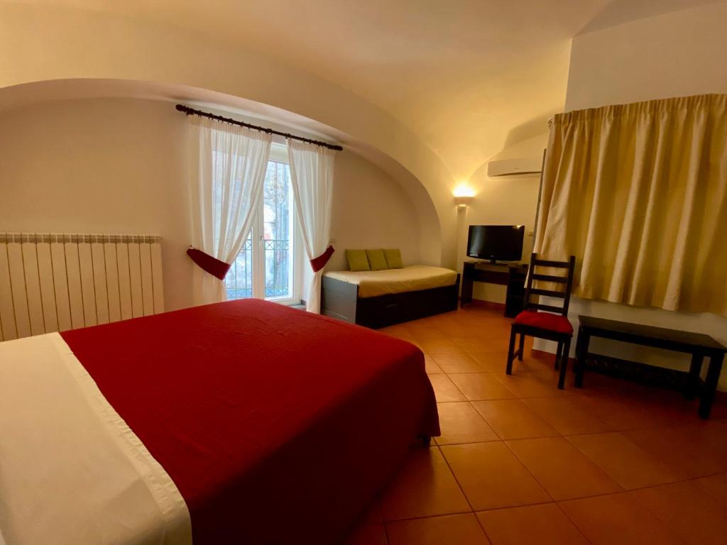 ナポリにあるBorgo Belvedereの赤いベッドと椅子が備わるホテルルームです。