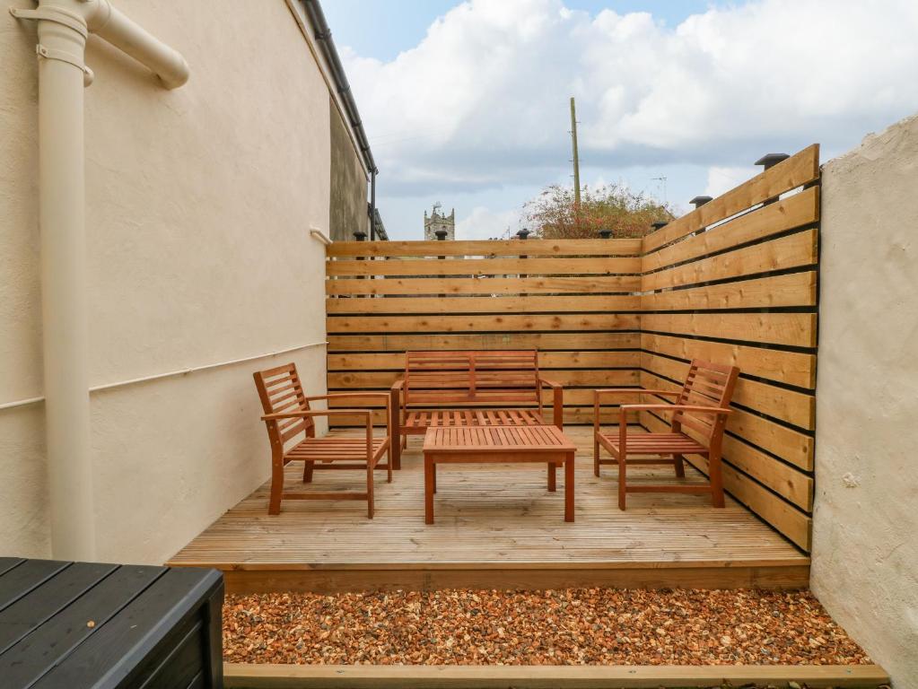 a patio with chairs and a table and a fence at Glanffrwd - Nefyn in Pwllheli