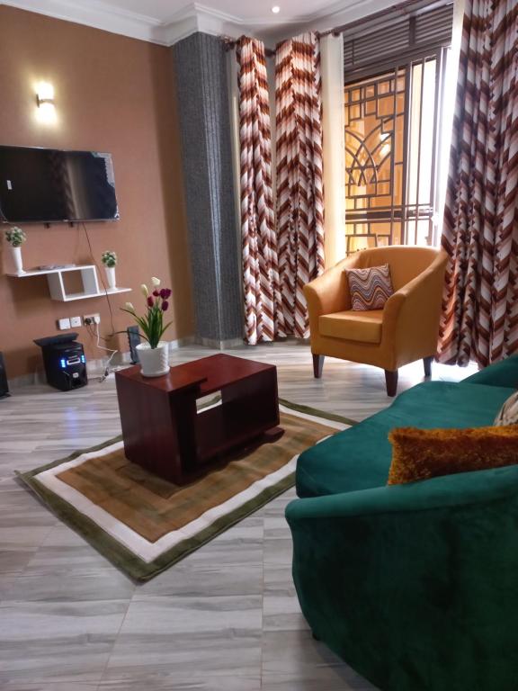 ein Wohnzimmer mit einem Sofa und einem TV in der Unterkunft nostiQ homes in Kampala