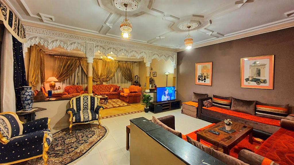 a large living room with couches and a tv at Oranger Family House - Marrakech in Marrakech