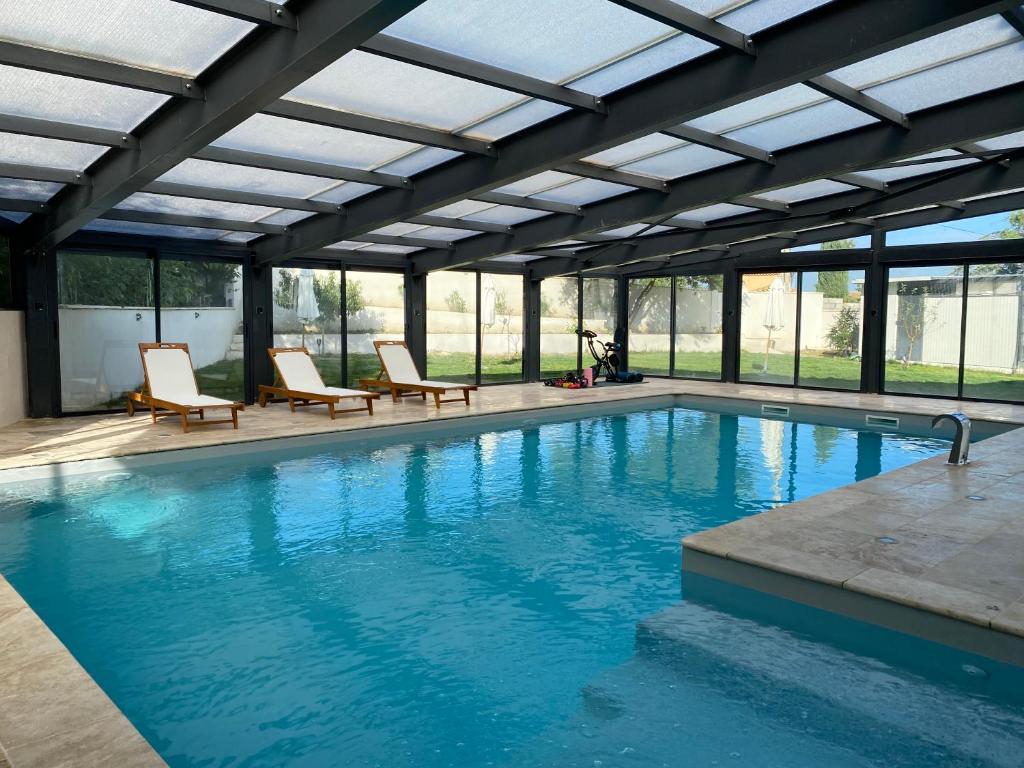 a large swimming pool with chairs and a large ceiling at O Bain Soleil in Bourg-Saint-Andéol