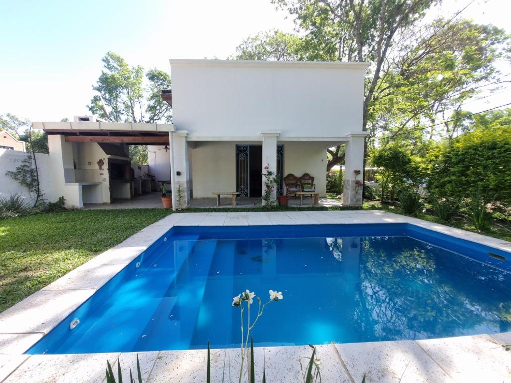 a villa with a swimming pool in front of a house at Casa en Paso De La Patria in Paso de la Patria