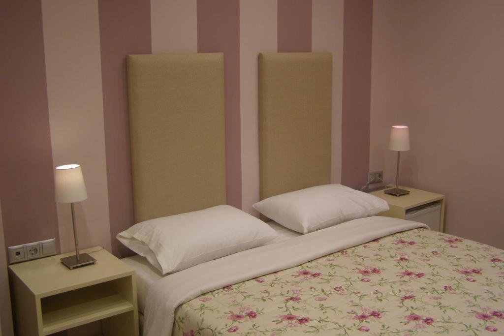 um pequeno quarto com uma cama e duas mesas de cabeceira em room "butterfly" in a neoclassical house em Kastoria