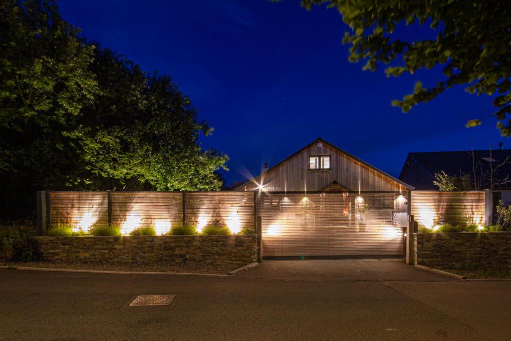 a barn with lights on a fence at night at Trelights Port Issac in Saint Endellion