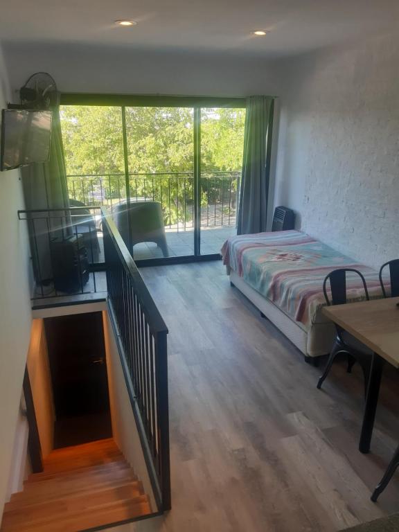 1 dormitorio con 1 cama y una escalera con balcón en PH playa Grande en Mar del Plata