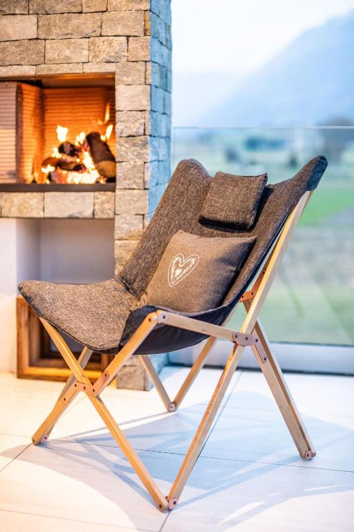 a folding chair in front of a fireplace at Bellevue Bruneck - Suites & Lofts in Brunico