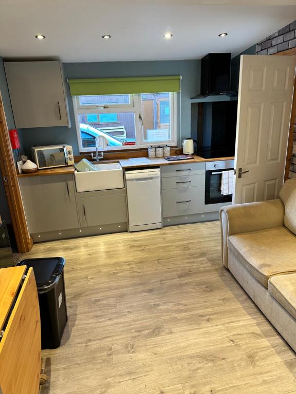 a living room with a couch and a kitchen at B3 Rickardos Holiday Lets in Mablethorpe