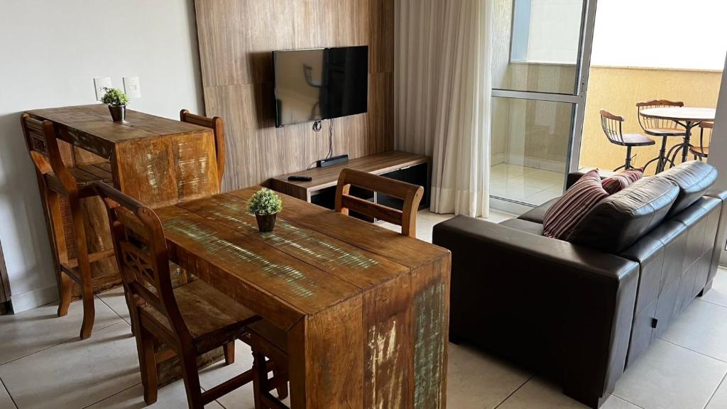 salon z drewnianym stołem i kanapą w obiekcie Flat Brookfield Towers 2409 w mieście Goiânia