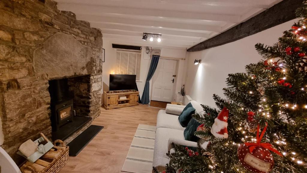 a living room with a christmas tree and a fireplace at The Cwtch in Brecon