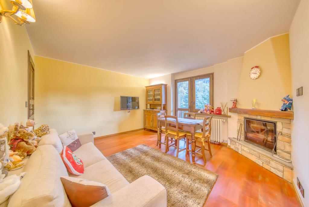 a living room with a couch and a fireplace at Elegante appartamento-100mt dal centro-50mt dalla seggiovia-wifi-parcheggio gratuito in Sauze dʼOulx
