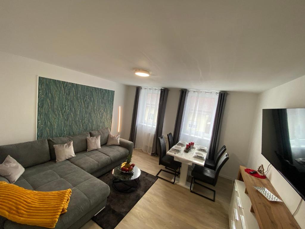 ein Wohnzimmer mit einem Sofa und einem TV in der Unterkunft Schöne Ferienwohnung „Zum Glück“ in Eisenach
