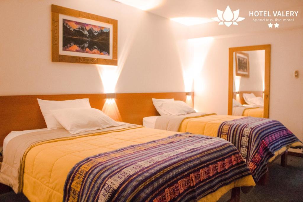 Habitación de hotel con 2 camas y espejo en Hotel Valery 2 estrellas, en Huaraz