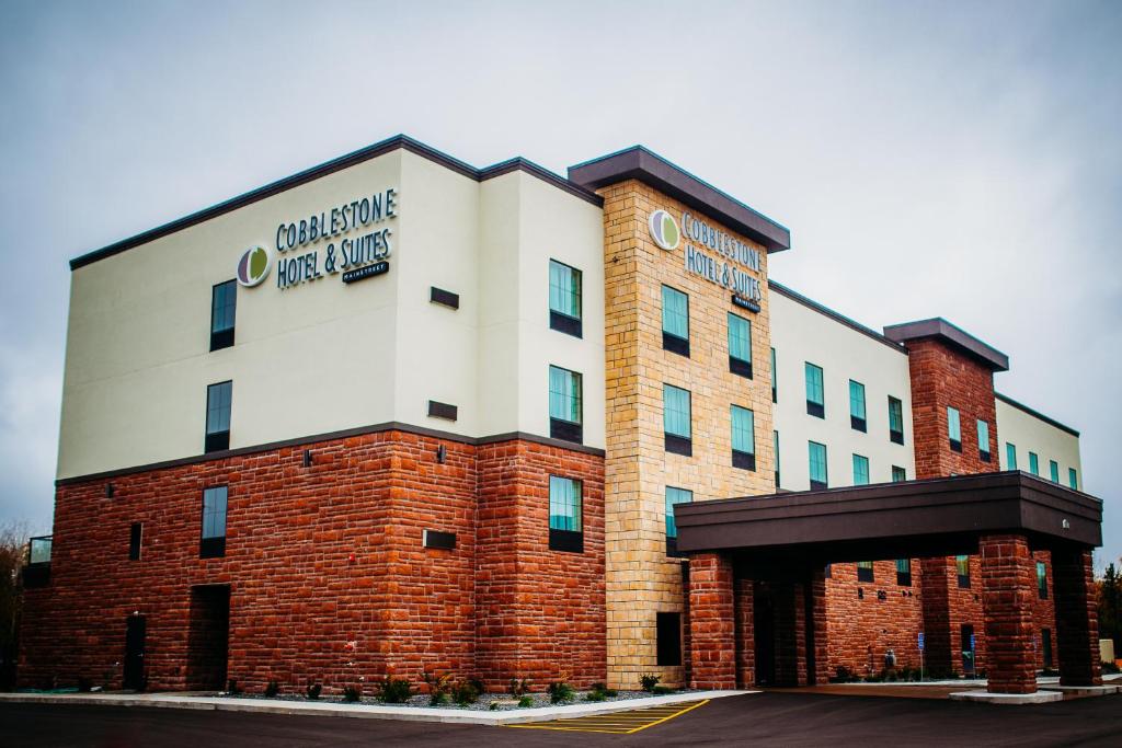 a large brick building with a sign on it at Cobblestone Hotel & Suites International Falls in International Falls