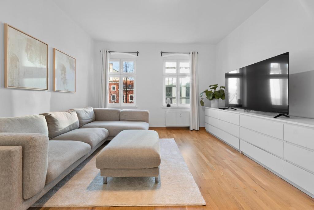 a living room with a couch and a flat screen tv at Beautiful 80sqm Appartment in Berlin-Mitte in Berlin