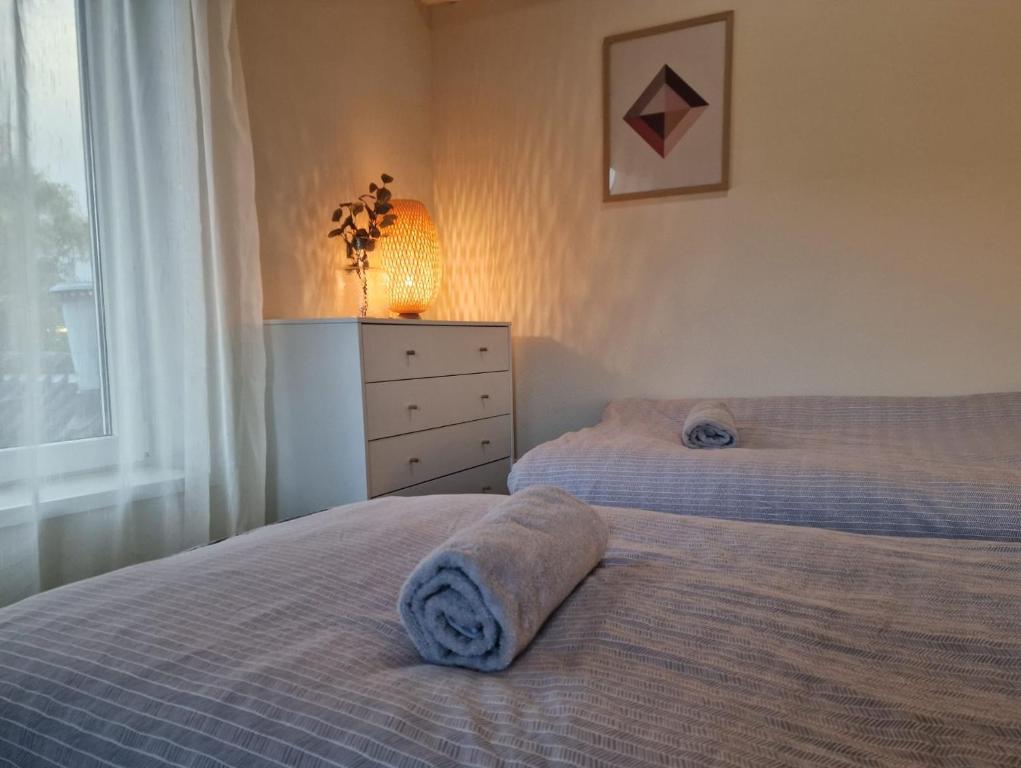 a bedroom with two beds and a dresser and a lamp at Staying-Inn Enschede in Enschede