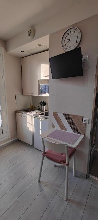 cocina con mesa y reloj en la pared en studio-centre-Thabor-balcon-1 personne en Rennes