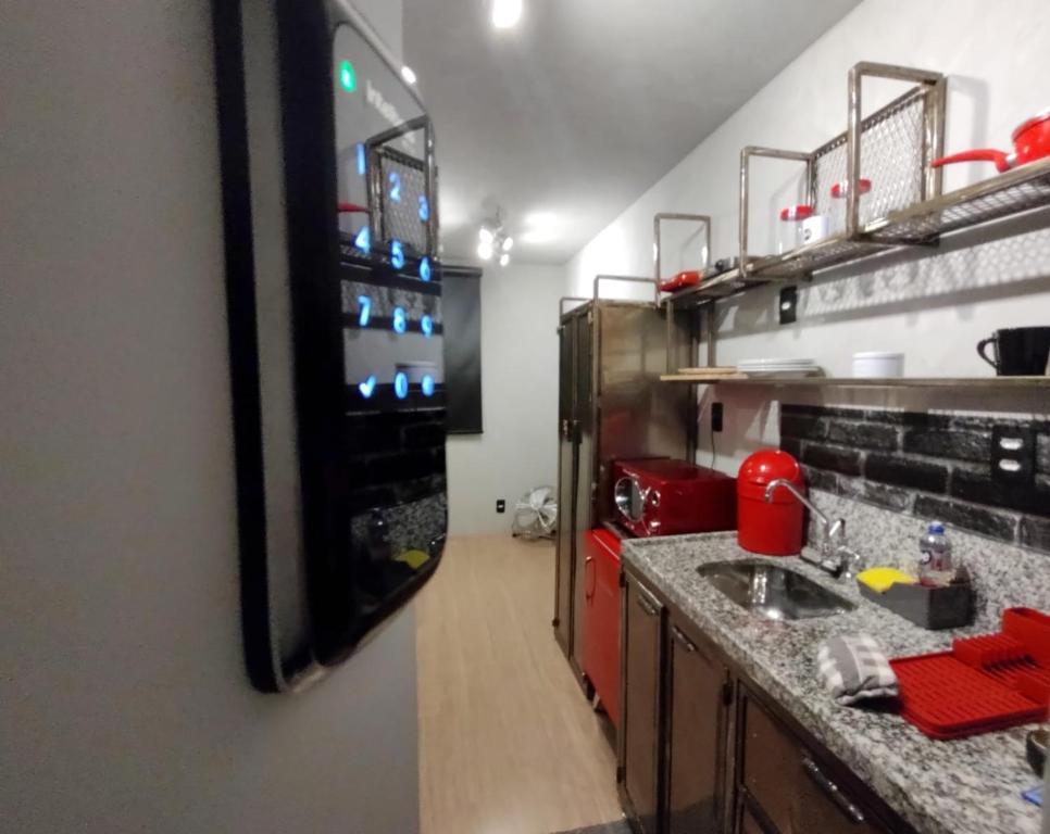 een keuken met een wastafel en een koelkast bij Brás - O Melhor Studio 200m Estação in Sao Paulo
