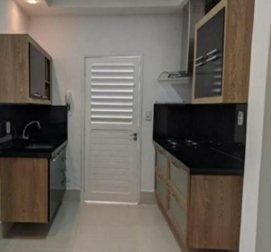 eine Küche mit einem Waschbecken und einer weißen Tür in der Unterkunft FlatStudio02 em condomínio residencial na Nova Betânia in Mossoró