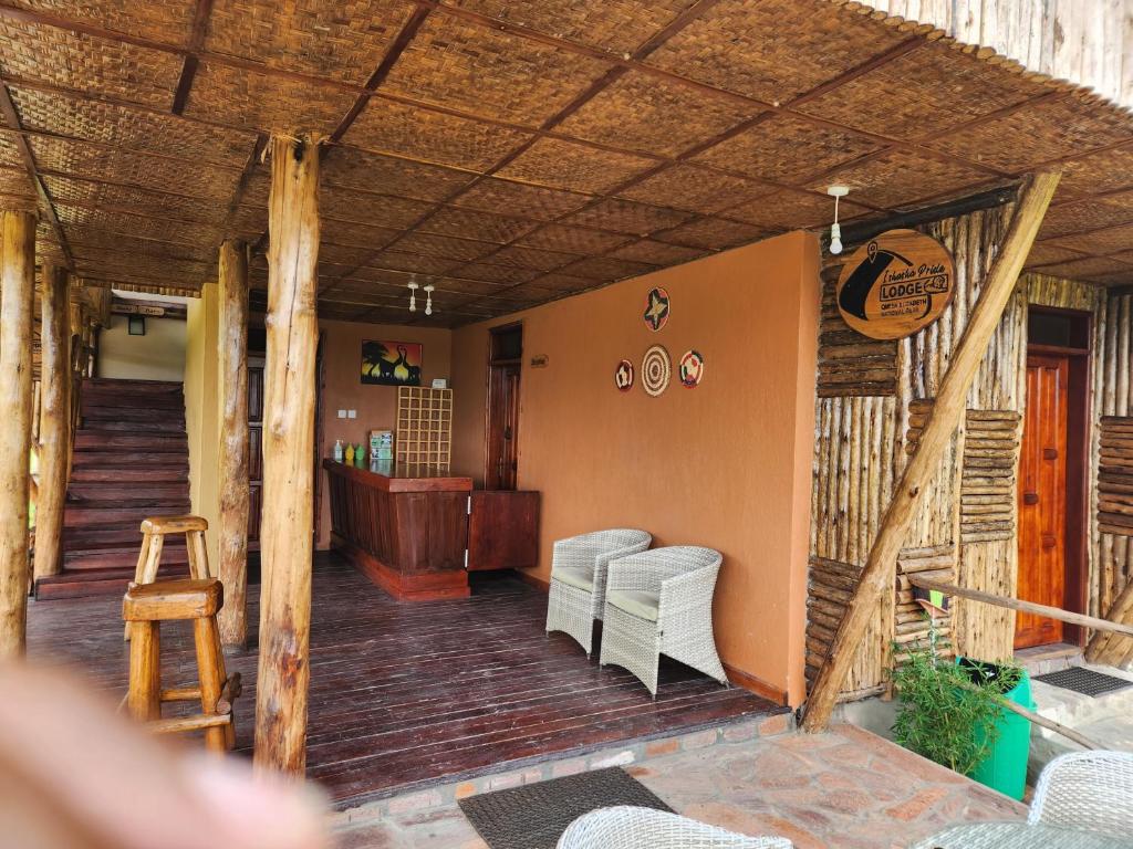 a porch of a house with chairs and a table at Ishasha Pride Lodge in Kihihi