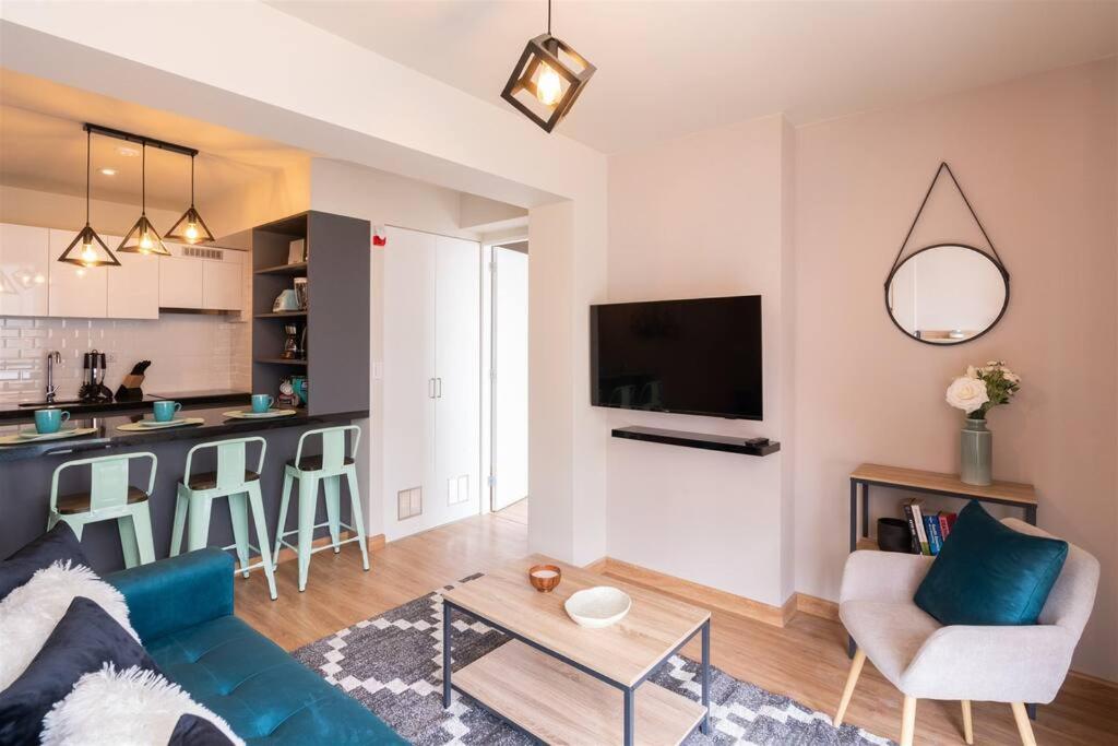 利馬的住宿－Elegant&Modern Apt in San Isidro，一间带蓝色沙发的客厅和一间厨房