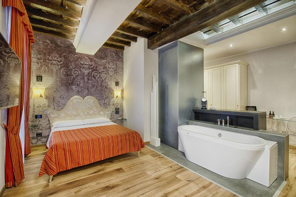 a bedroom with a large bed and a bath tub at Luxury Ripetta 2 in Rome