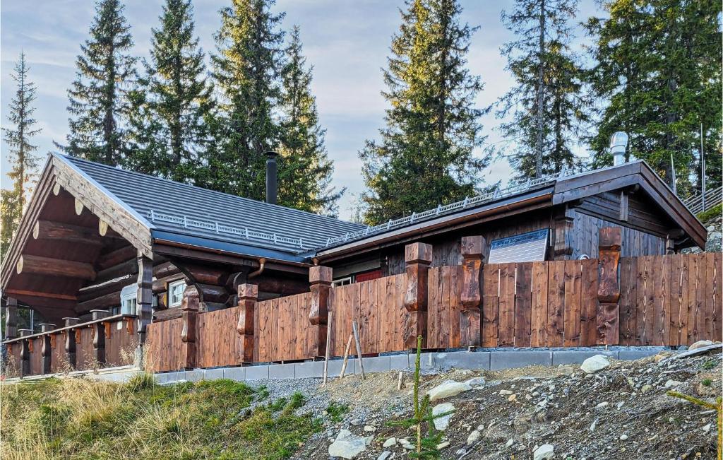 a log home with a fence in front of it at Nice Home In Aust-torpa With Kitchen in Aust-Torpa