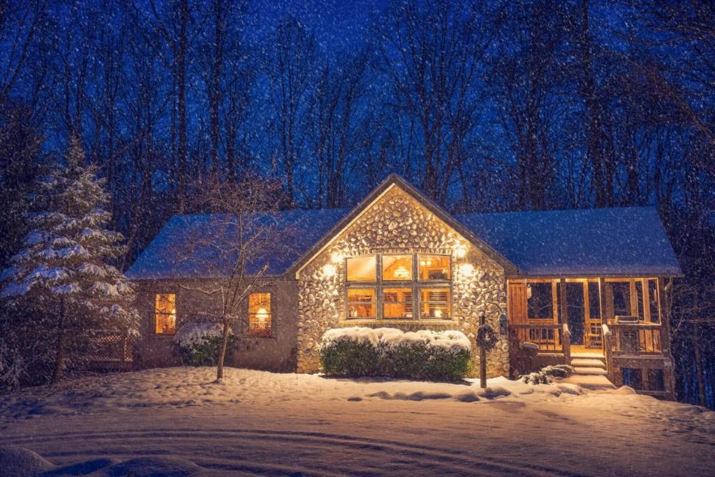 a house covered in christmas lights in the snow at Cherry Ridge Retreat Luxury Cabins 