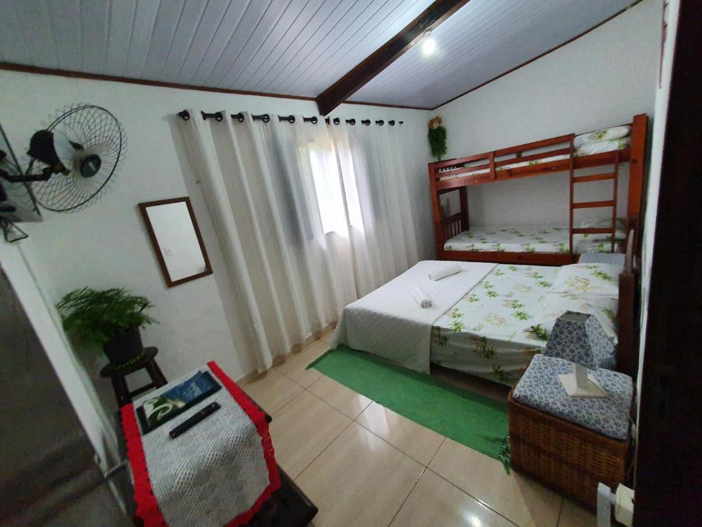 1 dormitorio con litera y silla en Casa da cachoeira - Ilhabela, en Ilhabela