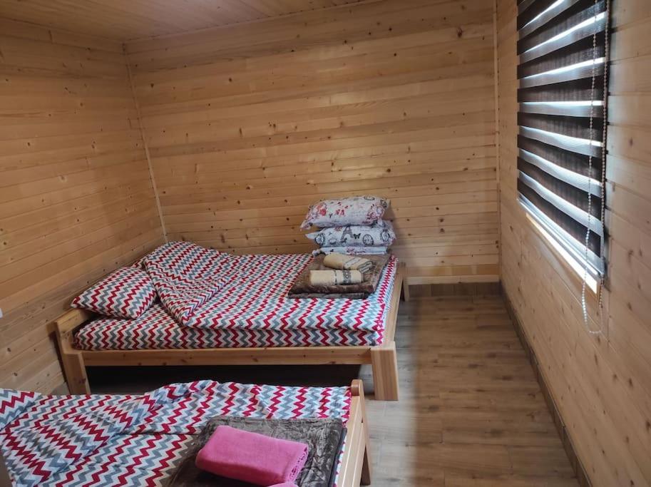 a room with two beds in a wooden cabin at Homoljski Raj Banja Zdrelo in Ždrelo
