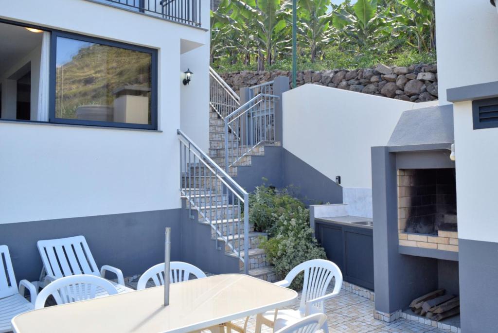 CampanárioにあるCasa Calhau da Lapa, a Home in Madeiraのパティオ(白い椅子、テーブル、階段付)