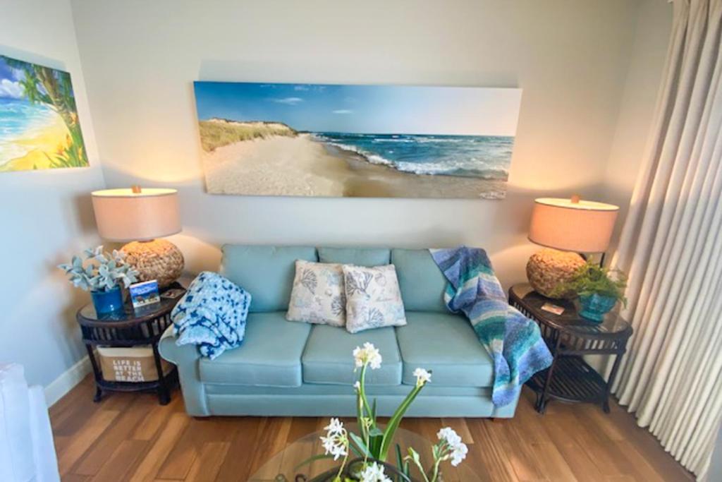 a living room with a blue couch and two lamps at Sterling Breeze 1803 in Panama City Beach