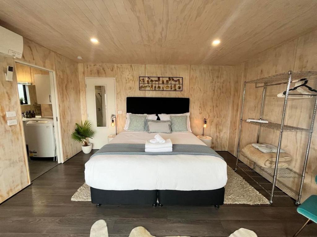 a bedroom with a large bed in a room with wooden walls at Wayfarer Lodge Studio in Lake Tekapo